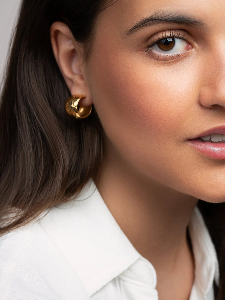 Model wearing 24K gold-plated chunky hoop earrings, a bold and elegant statement.