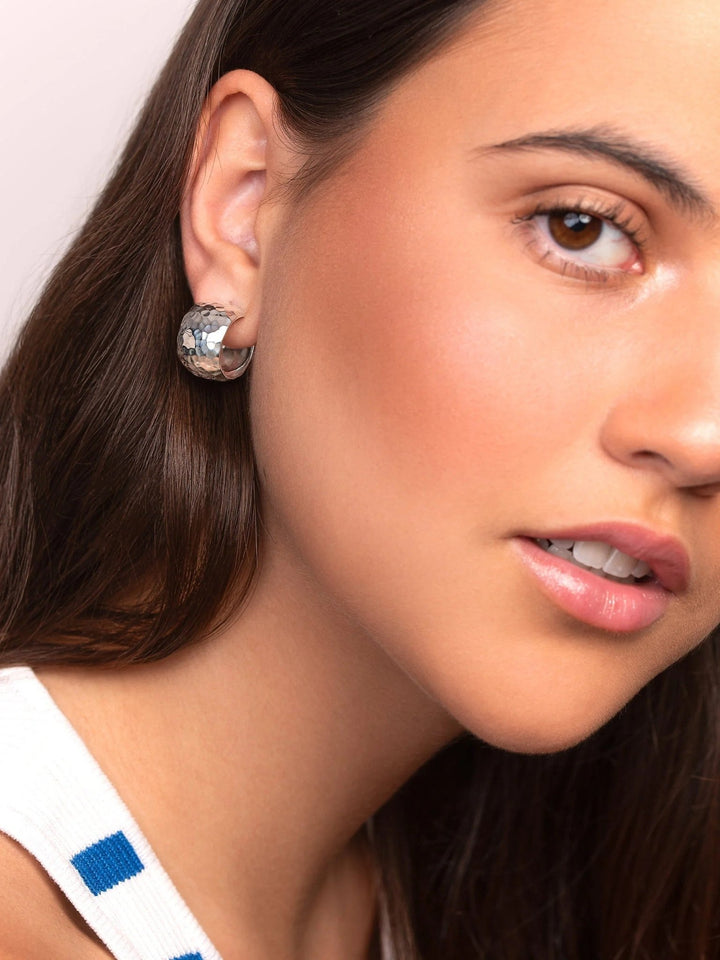 Model wearing sterling silver wide hoop earrings, bold yet elegant design.